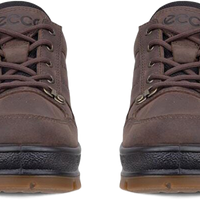 A pair of brown suede low-top sneakers shown from the front on a white background, featuring dark brown laces, black soles, and small gold accents.