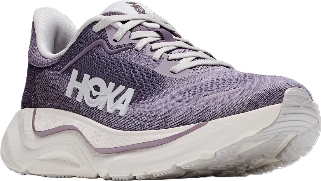 A Hoka running shoe in a dusty lavender-purple and white colorway, featuring a textured mesh upper, white laces, and a thick white cushioned sole with a purple accent line.
