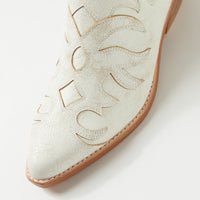 White cowboy boot with brown sole on a light gray background
